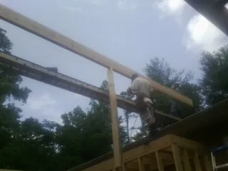 Carpenter setting a ridge beam over a new addition frame — Ice Dam Removal by Roofing Brothers in Lynnfield