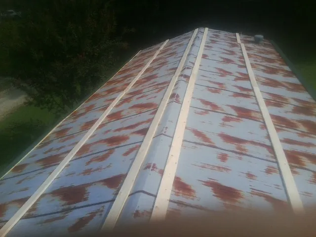 Rusted metal roof panels with new wood purlins before replacement — Storm Damage Roof Repair in Lynnfield by Roofing Brothers