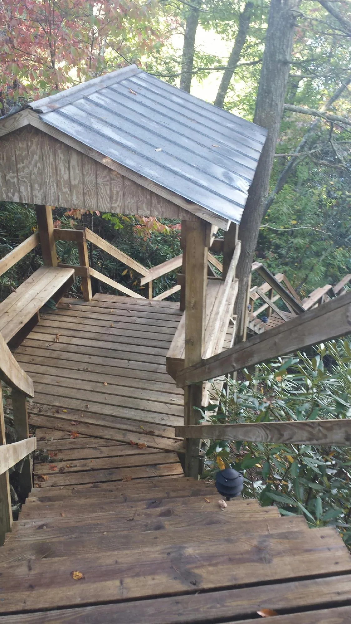 Metal roofed shelter over wooden steps on a wooded walkway — Skylight Repair & Installation work by our crew in Lynnfield