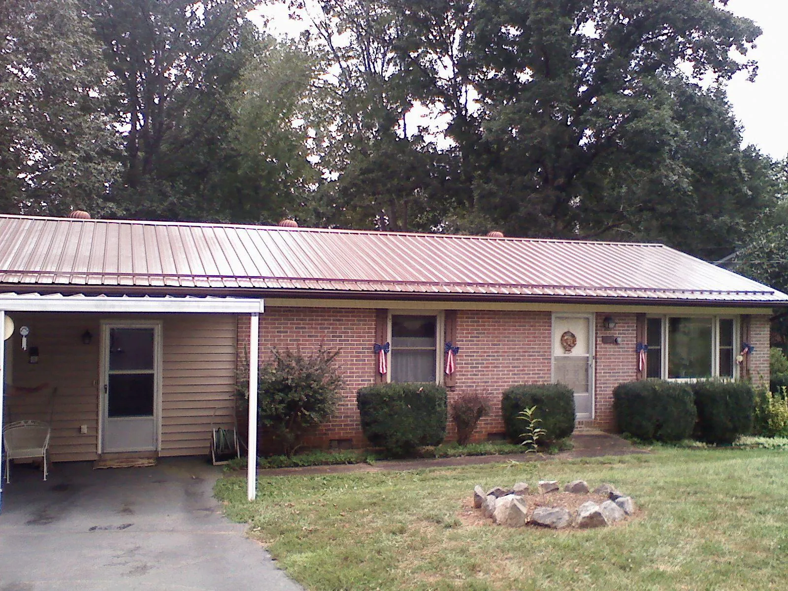 Bronze metal roof and carport on a brick ranch home — Roof Repair work by our crew in Lynnfield